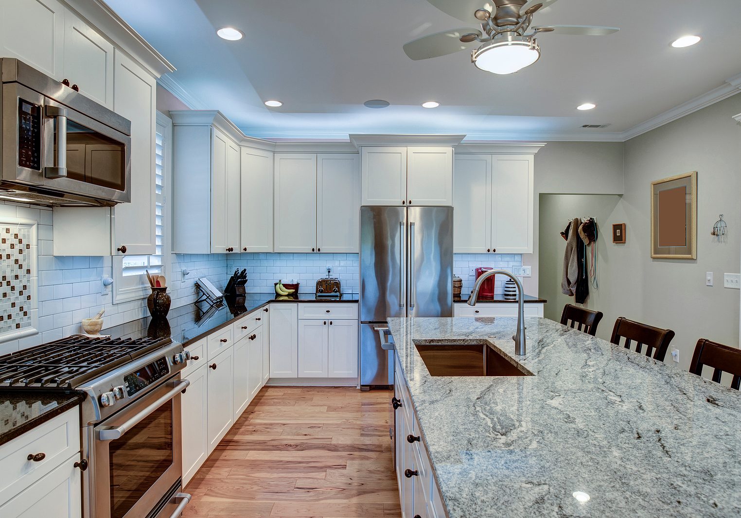 Beautiful luxury kitchen with quartz and granite countertops and white cabinets.