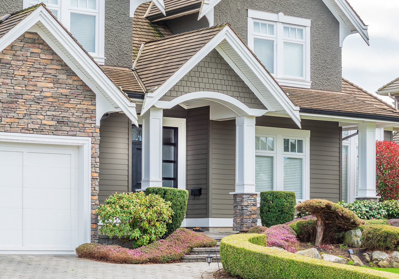 A perfect neighborhood. Houses in suburb at Spring in the north America. Fragment of a luxury house with entrance door and nice window.