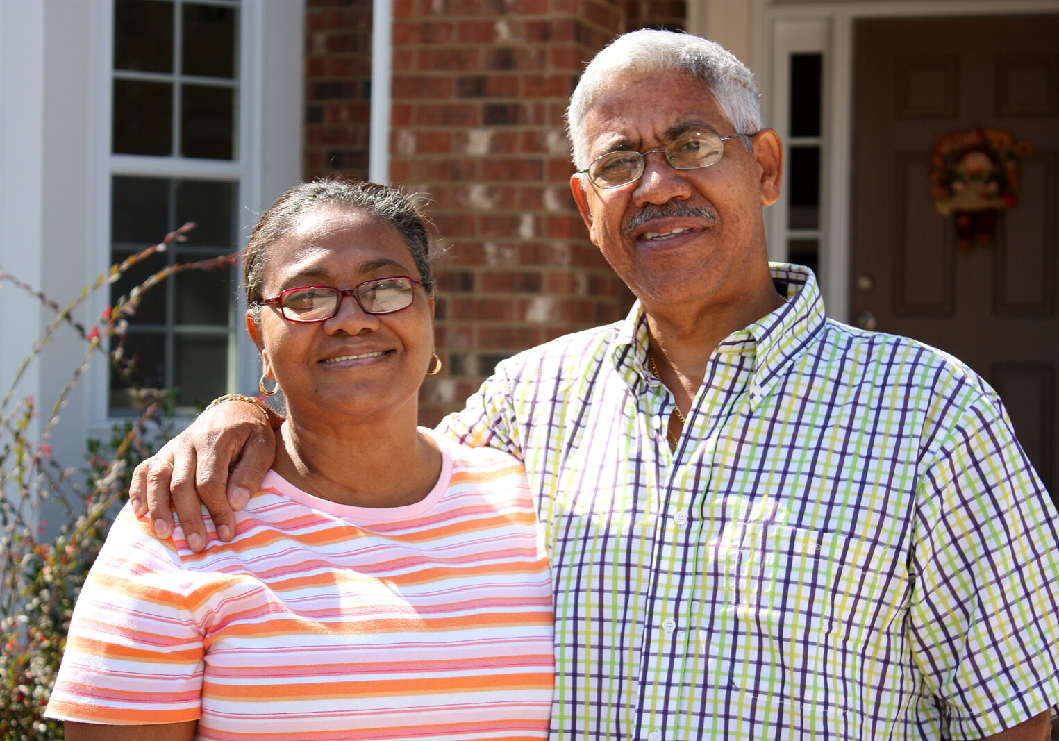 Senior Minority Couple Standing Outside Their Home